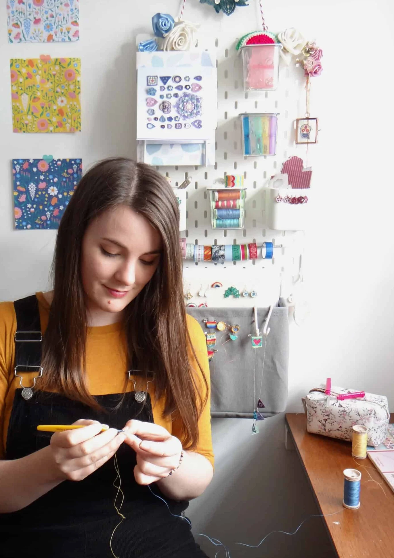 Micro crochet designer Steffi Glaves sitting at desk crocheting a tiny flower